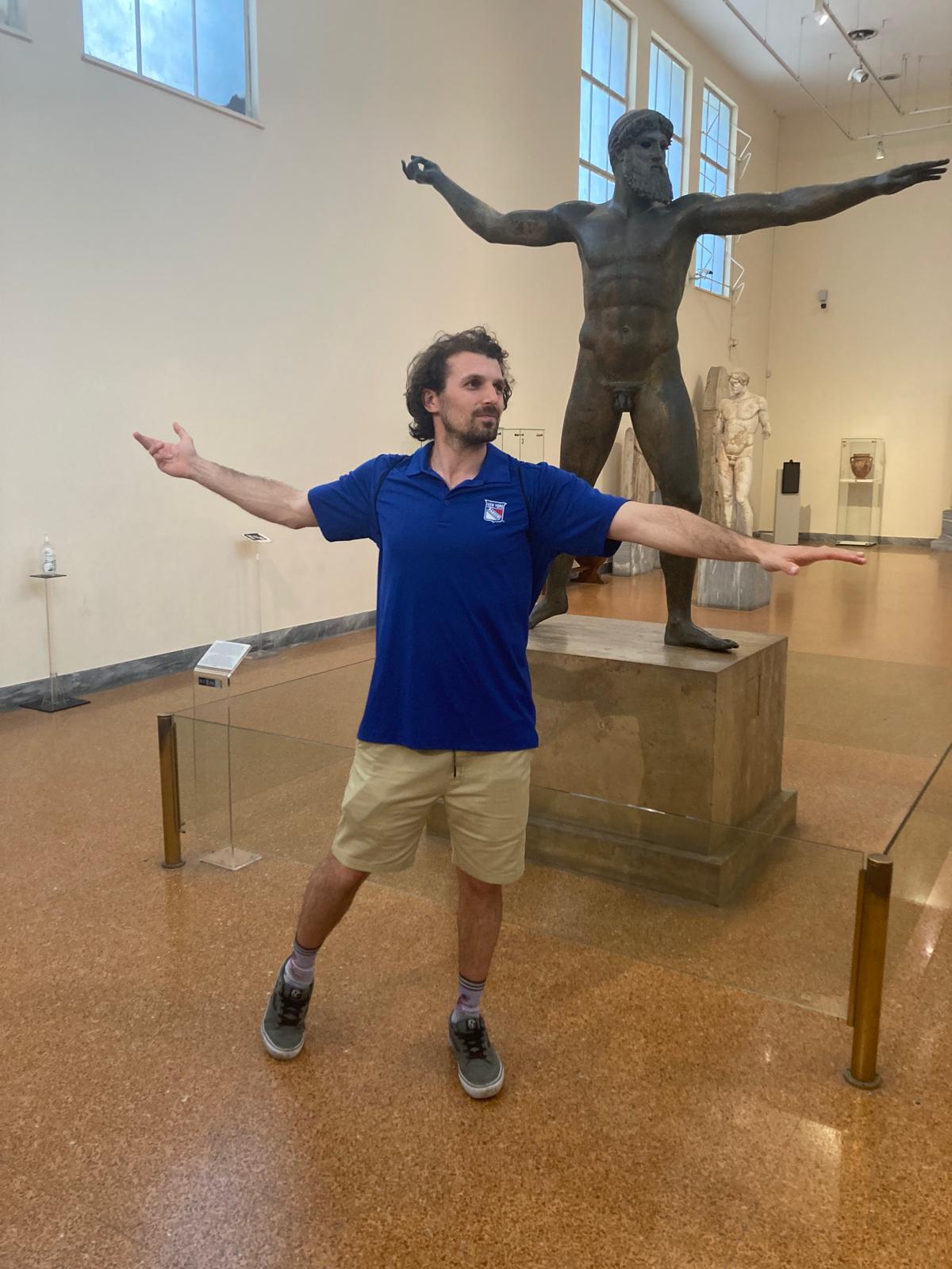 Gregory at a museum doing an impression of a Greek bronze statue