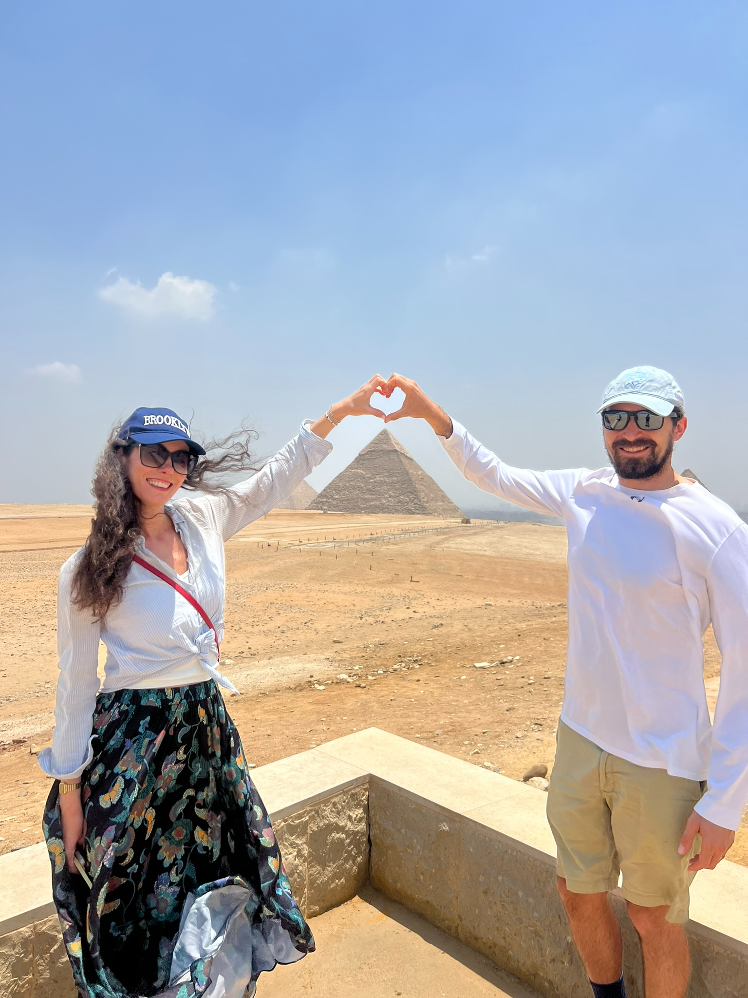 Gregory and Sherah making a heart with their hands in front of the Egyptian Pyramids